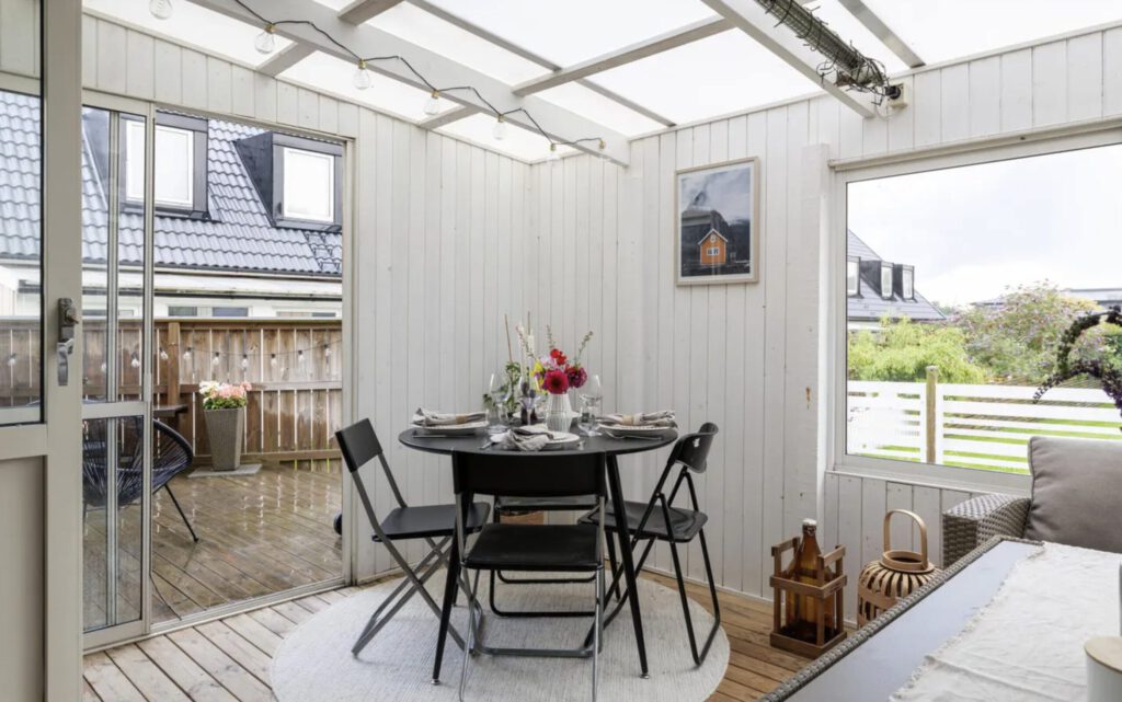 Ljust uterum med runt matbord, dukning och fotografisk poster från Posterium på väggen som skapar en naturnära känsla.